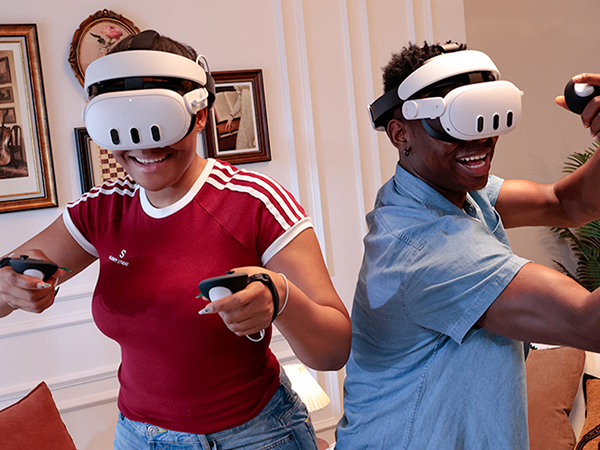 Two individuals playing VR games with H4 Boost Halo Battery Strap