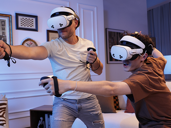 Two individuals playing VR games with H4 Boost Halo Battery Strap